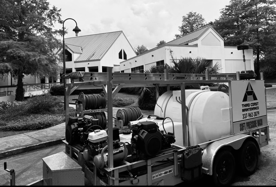 Third Coast Maintenance technician soft washing the exterior of a commercial building